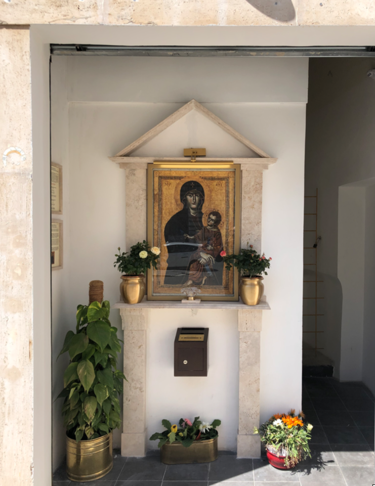 Primo piano dell’edicola della Salus Populi Romani, con l’immagine della Vergine e del Bambino, fiori e piante.