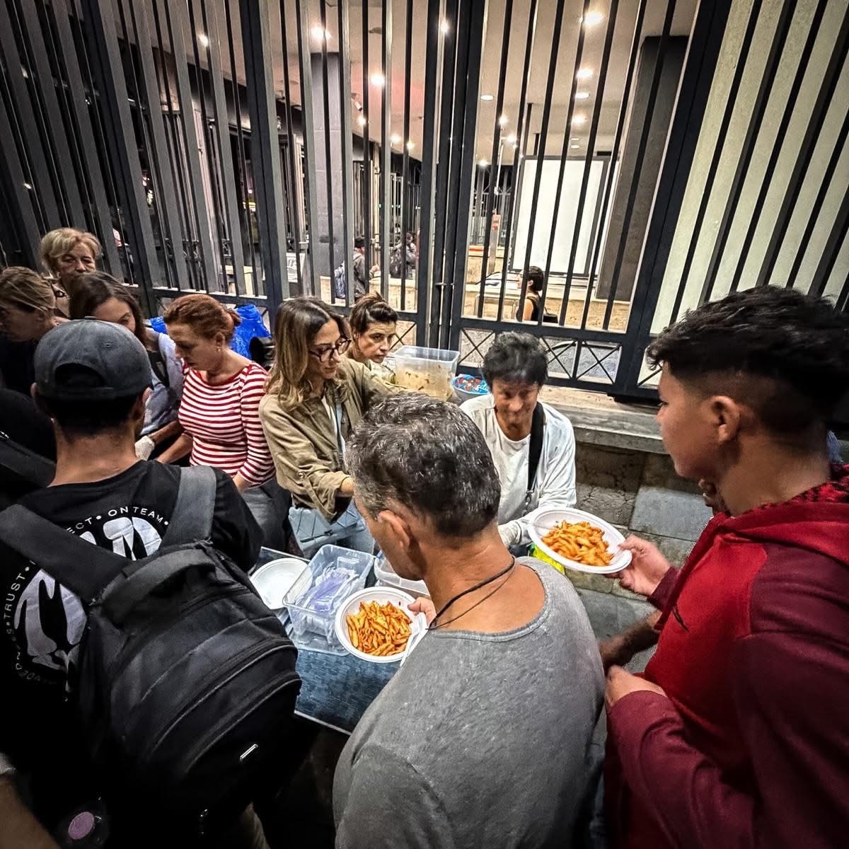 I volontari distribuiscono la cena presso la stazione Termini